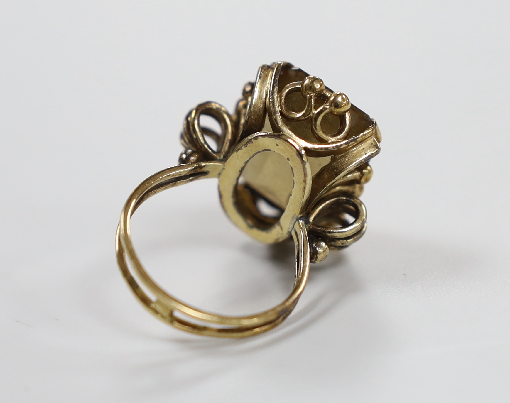 An early 20th century yellow metal and emerald cut citrine set dress ring, size R/S, gross weight 12 grams.